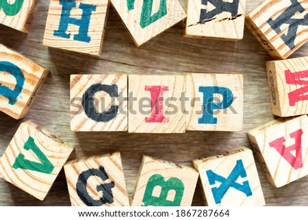 Alphabet letter block in word CIP (Abbreviation of Carriage and Insurance Paid To) with another on wood background