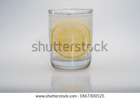A glass of water with a lemon slice in a studio environment