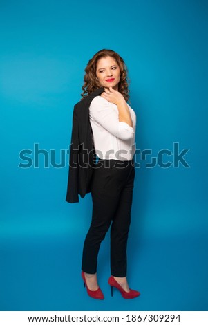 Young beautiful business woman in black suit and white shirt isolated on blue background. Full height. Vertical. 