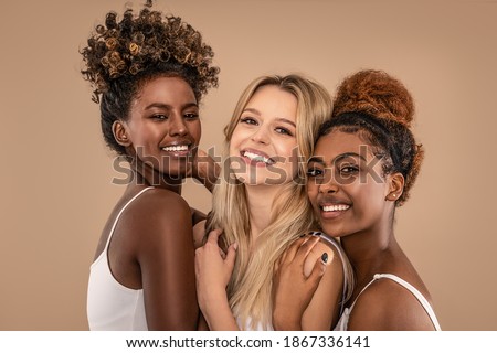 Three Beautiful Diverse Girls Posing together, smiling and looking at camera. Facial Skincare. Group of happy multiethnic woman posing in studio. Royalty-Free Stock Photo #1867336141