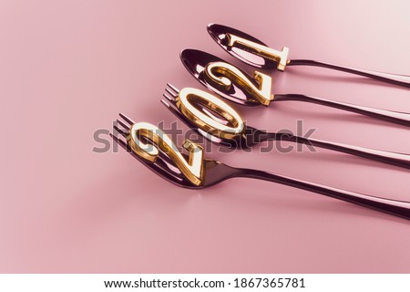 New year 2021. Golden numbers on a black shiny metal cutlery on a pink background. New year concept. Modern creative holiday template. 