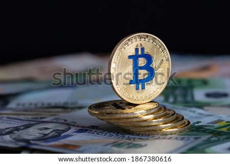 Bitcoins close-up on the background of paper bills of different countries.