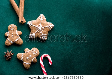 Green background with free space with cinnamon, gingerbread men, stars snowflakes  Royalty-Free Stock Photo #1867380880