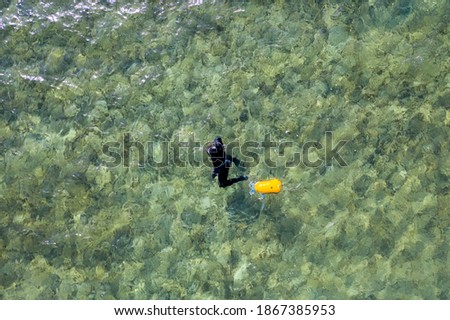 A man  is  swimming in a riff on BatGalim  Haifa beach