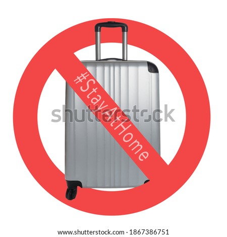 Silver Suitcase on a white background with international no symbol and #stayathome. Cancelled trip tourism restrictions concept during COVID-19 pandemic.  Royalty-Free Stock Photo #1867386751