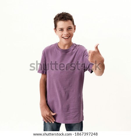 Happy teenaged disabled boy with cerebral palsy smiling and showing thumbs up at camera, posing isolated over white background. Children with disabilities and special needs concept. Front view