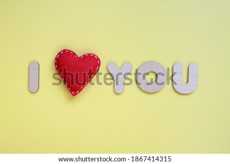 I love you concept on yellow. Red felt heart and wooden letters. Postcard design template for birthday, mother's day, valentine's day and other holidays and events.