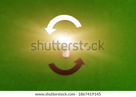 The light bulb is shining, two rounded arrows are white and black on a green background. Creative business ideas, mind, creativity.