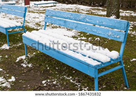 Snow covered benches in the yard closeup