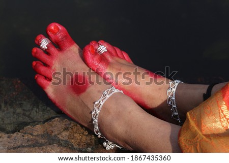 Close up picture of new bride feet decorated with red color ( Alta ). The feet of new bride wearing anklets and rings. Beautiful composition of new bengali bride feet. Selective focus concept.