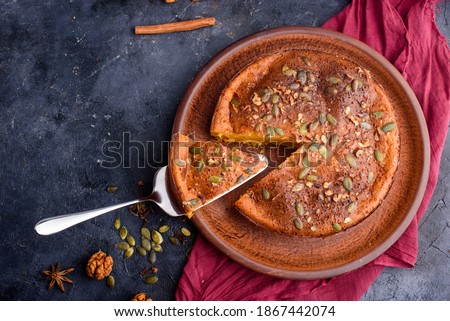 Pumpkin pie with lemon zest, pumpkin seeds, cinnamon, fragrant spices and spices on a dark background. Healthy and delicious food