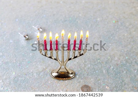 Jewish candlestick menorah with burning candles on sparkle background. Hanukkah holiday.