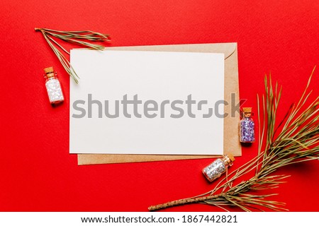 Blank christmas note with fir branch and spruce toy on red isolated background. New Year concept