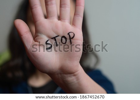 Woman holding her hand covering her face. Message 'Stop' is written on hand Royalty-Free Stock Photo #1867452670