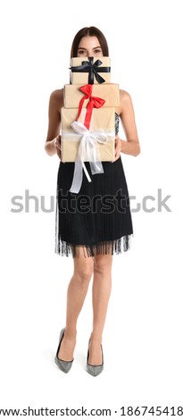 Woman in party dress holding Christmas gifts on white background