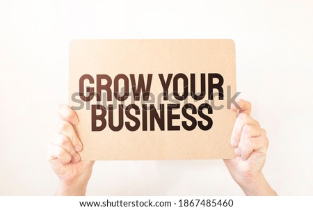 Closeup Business man hand holding show blank paper sheet mock up empty white board space for shouting text rule or protest word. Text GROW YOUR BUSINESS