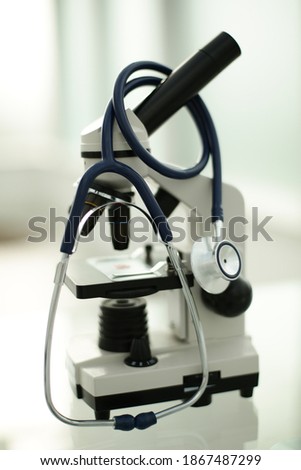 Stethoscope microscope and pills on glass table