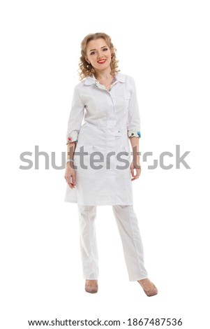 Beautiful smiling woman blonde doctor in medical clothes stands in full growth isolated on a white background.