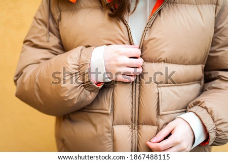 Young woman while standing against yellow wall