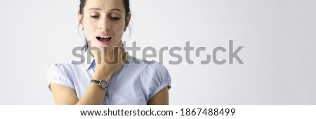 Frustrated woman holds her throat with her hand and coughs. Respiratory tract disease concept Royalty-Free Stock Photo #1867488499