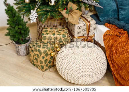 A cozy room decorated with garlands and Christmas trees. White pillow-bed is stylish and modern. Good New Year spirit. Light colors background texture place for text. Bedroom decor for the holiday