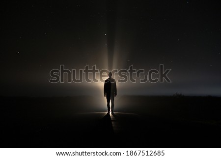 backlighting of a man in the dark of a foggy night and a light behind the model Royalty-Free Stock Photo #1867512685