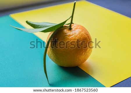 Fresh orange tangerine with green leaves isolated on colored background. Food levitation concept. Healthy food, ripe fruits, citrus fruits.Copy space