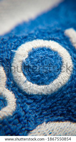 White embroderied letter o in blue towel