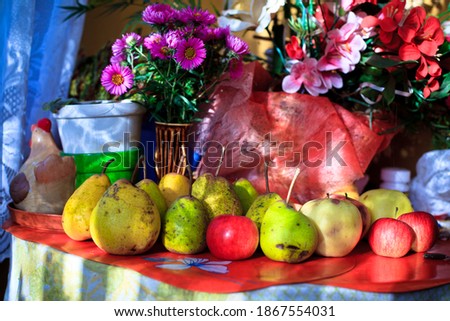 Autumn fruits and fake flowers on the table