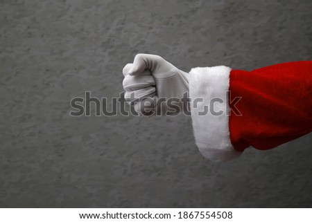 closed hand with Santa Claus glove.