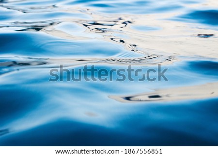 photo of water surface waves reflecting the light of the sun