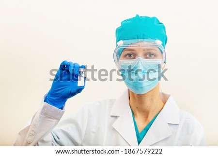 Doctor or nurse holding hands flu vaccine on beige background, measles injection syringe for baby, man, woman vaccination, medicine and drug concept. Vaccination against Coronavirus covid-19 pandemic 
