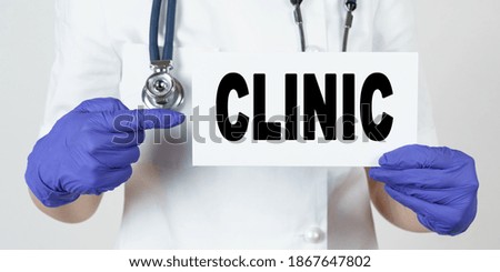 Medicine and health concept. The doctor points his finger at a sign that says - CLINIC