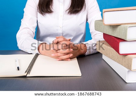 Close up of a woman's hands spreading a notebook on the table and putting both hands together