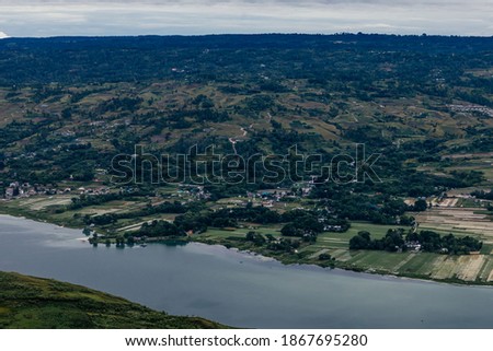 Beautiful landscape and agriculture rice fields in the valley and mountain surrounding the shore of Lake Toba. Bukit Holbung, Samosir Regency, Lake Toba, North Sumatra, Indonesia