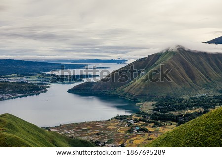 Beautiful landscape and agriculture rice fields in the valley and mountain surrounding the shore of Lake Toba. Bukit Holbung, Samosir Regency, Lake Toba, North Sumatra, Indonesia