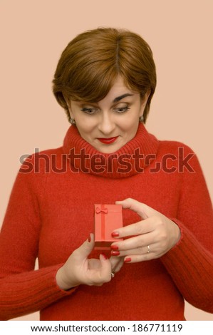 Woman in red woolen turtleneck sweater holding a gift box