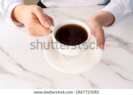 Close up of a woman's hand holding a coffee mug