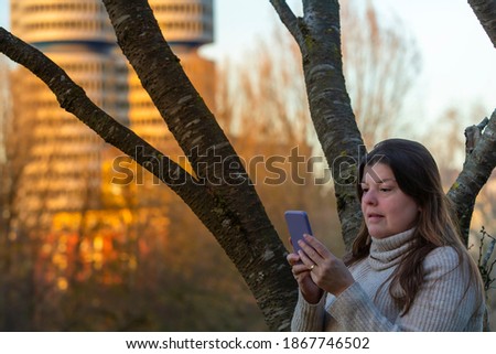 Business woman uses her smartphone outside her office. 