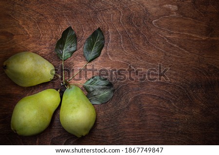 group and three pears in a rustic style on a dark wooden background