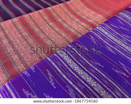 Thai traditional woven clothes . Thai villagers in rural areas weave fabrics to earn income during the end of the farming season. Weaving by hand loom. Thai wisdom production to fashion.