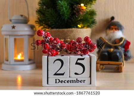 Wooden calendar with date December 25 against Christmas festive background. Beautiful home decor composition for Christmas holiday. Cozy home decor, winter mood. Selective focus