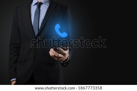 Businessman man in suit on black background hold phone icon.Call Now Business Communication Support Center Customer Service Technology Concept