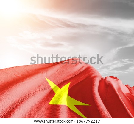 Vietnam national flag cloth fabric waving on beautiful sky background.
