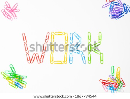 Word work.Made of colored bright paper clips on white background,top view.Close up