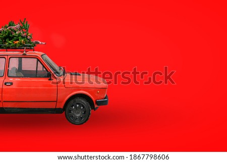 Christmas tree on the roof of the car. Red retro car. Delivery of goods, New Year's trips and tours. Christmas background