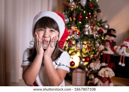 Little girl wearing Santa hat in Christmas decoration