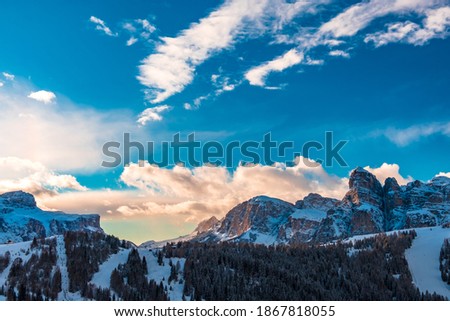 Sun goes down on an alpine valley in italy during a snowy winter