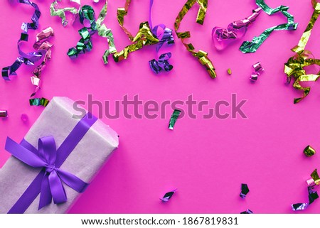 Christmas composition. Giftbox with ribbon and confetti decorations on pastel paper colorful background. Christmas, winter, new year celebration concept. Flat lay, top view, copy space