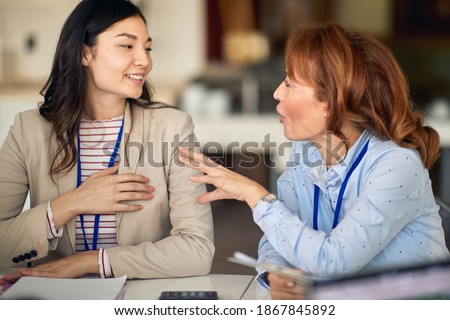 Young female colleagues discussing the job in a pleasant atmosphere in the company. People, job, company, business concept. Royalty-Free Stock Photo #1867845892